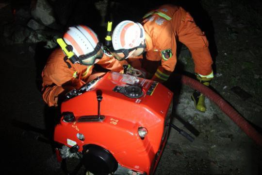 消防員到達現場后，利用手抬機動泵對道路進行排水